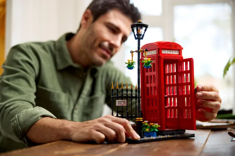 A man is building the Red London Telephone Box LEGO set.